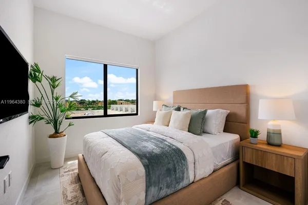 a large bed sitting in a bedroom next to a window