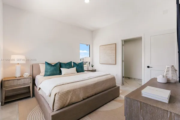 a bedroom with a bed and a lamp with the dresser