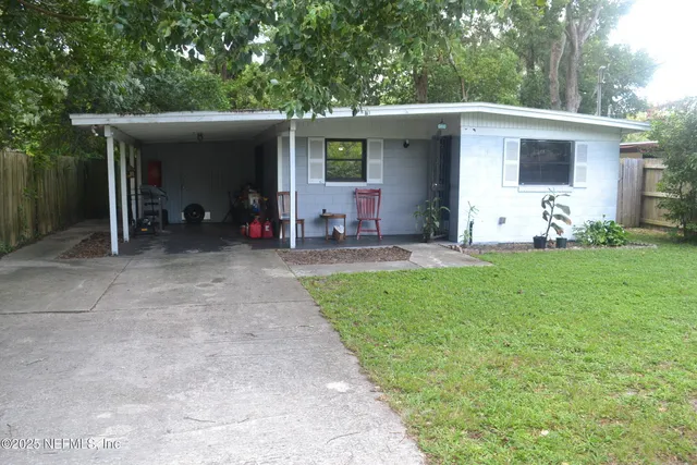 a view of a house with backyard and sitting area