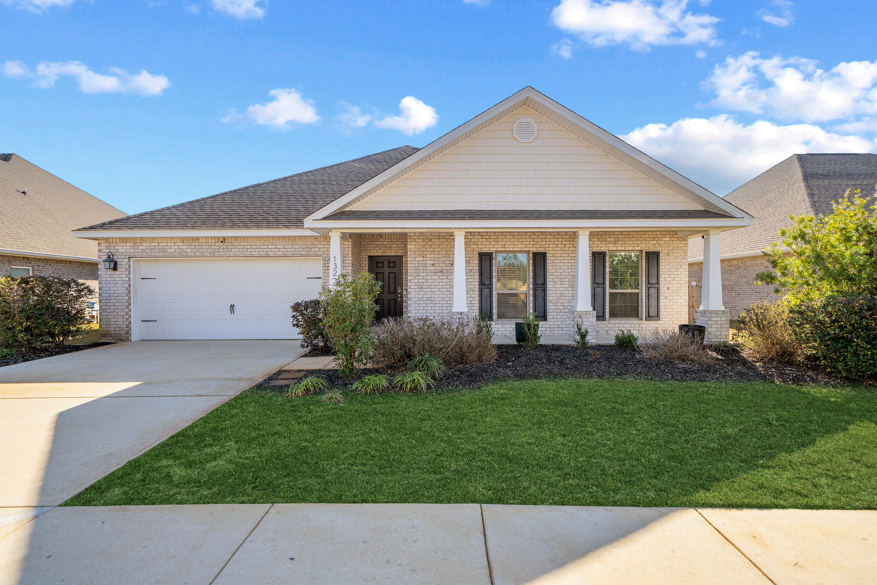 a front view of a house with a garden and yard