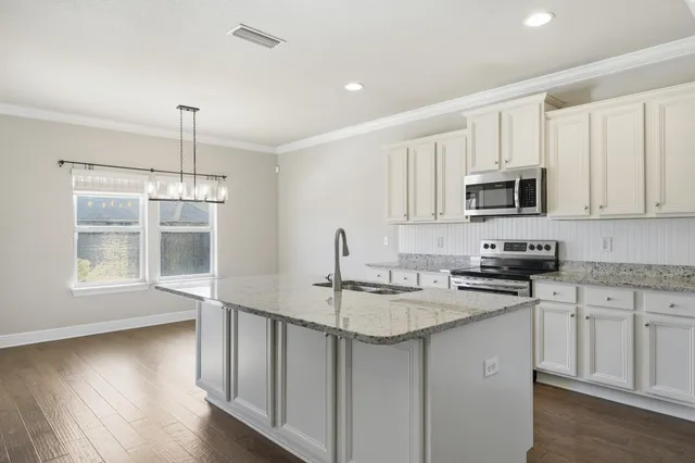a kitchen with stainless steel appliances granite countertop a sink stove and microwave