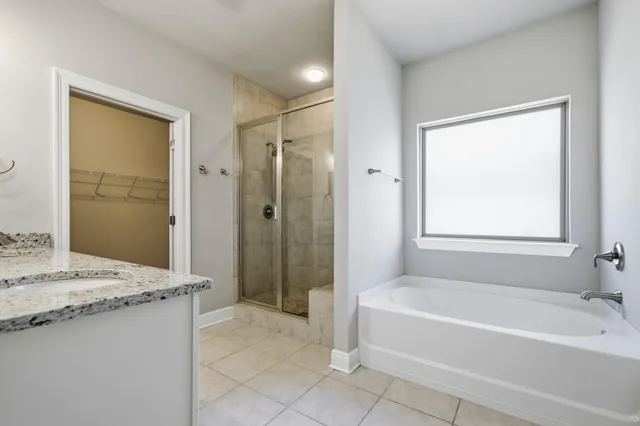 a spacious bathroom with a granite countertop tub sink shower and a mirror