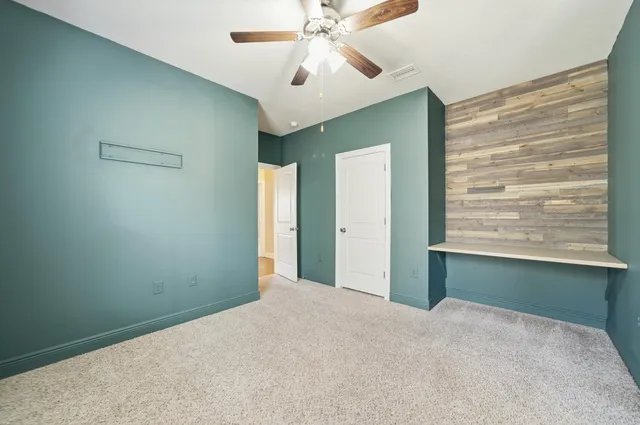 a view of empty room with window and ceiling fan