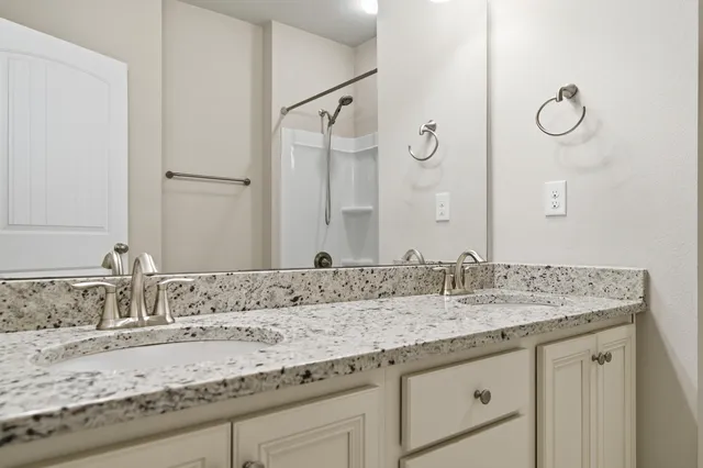 a bathroom with a granite countertop sink and a mirror