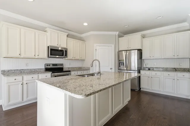 a kitchen with appliances a sink and cabinets