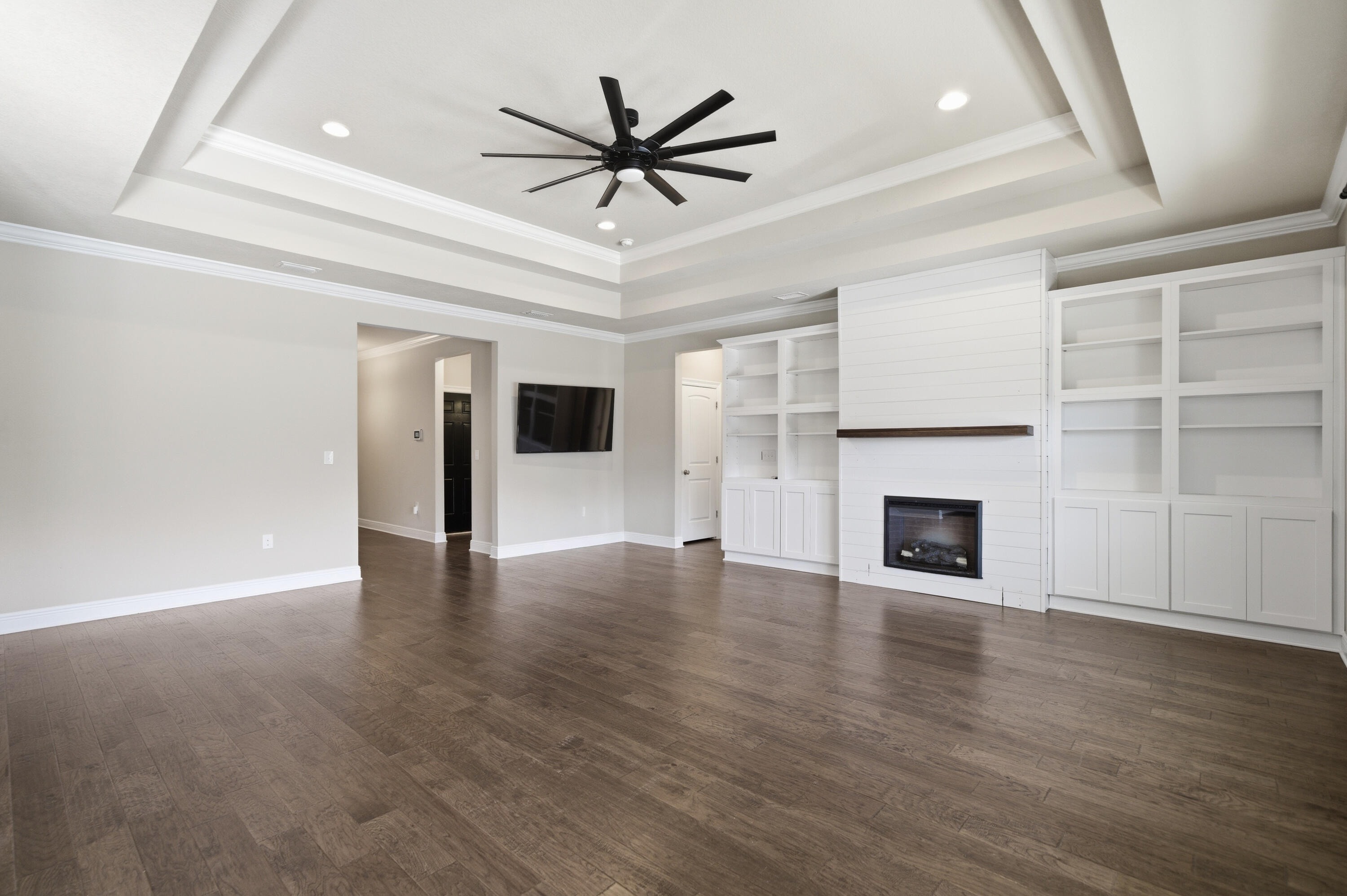 132 Wayne Trail Santa Rosa Beach, FL 32459 - Photo 9 of 43 a view of an empty room with a fireplace and a ceiling fan