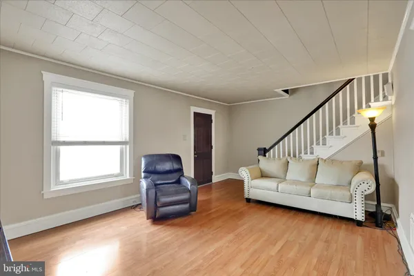 a view of an empty room with wooden floor and windows