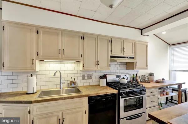 a kitchen with stainless steel appliances granite countertop a sink and a stove