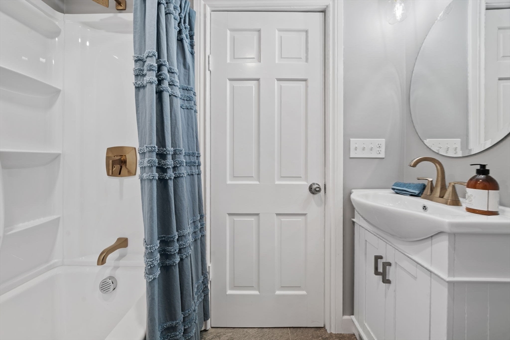 6 Puritan Lane Dedham, MA 02026 - Photo 28 of 41 a bathroom with a sink and mirror with bathtub