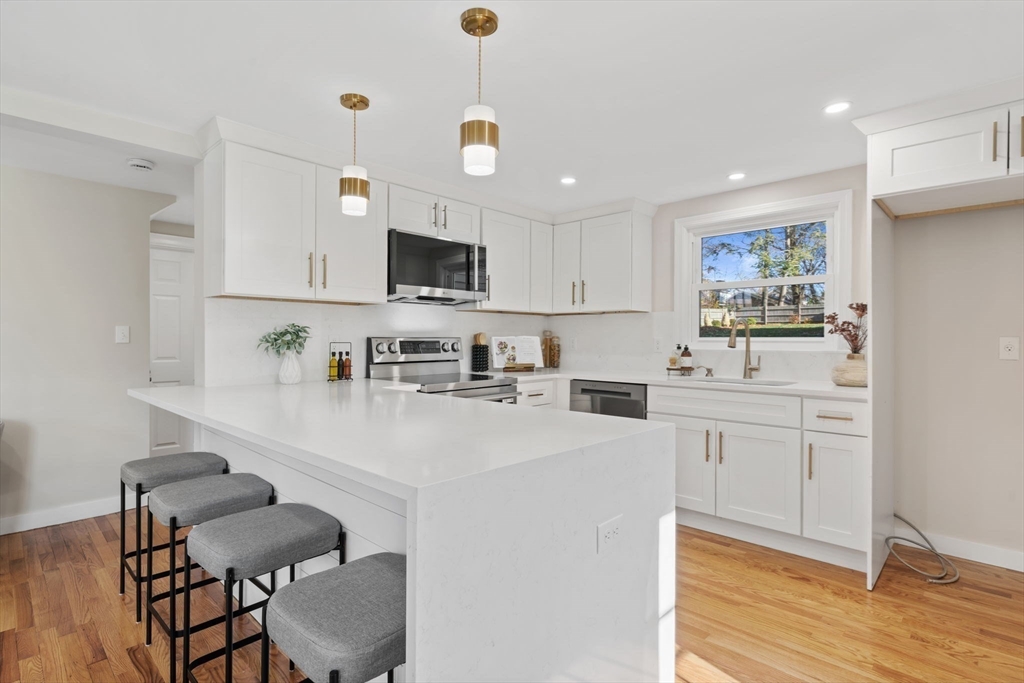 6 Puritan Lane Dedham, MA 02026 - Photo 6 of 41 a kitchen with stainless steel appliances a stove a sink a microwave a refrigerator and cabinets