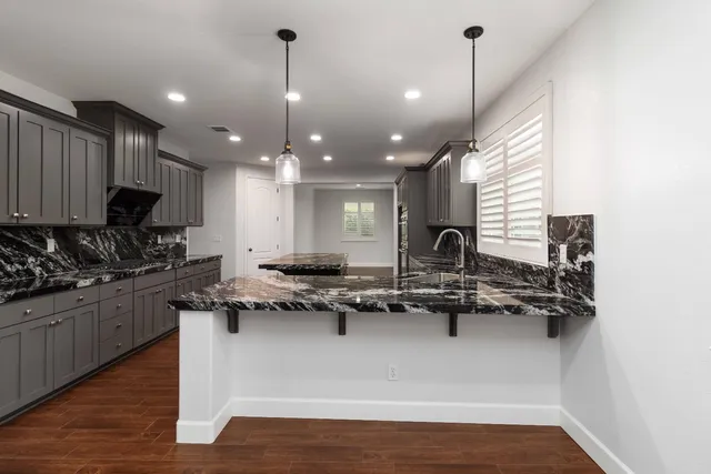 a kitchen with kitchen island granite countertop lots of counter top space and stainless steel appliances