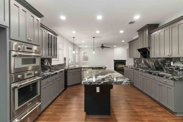 a kitchen with stainless steel appliances granite countertop a stove a sink and a refrigerator
