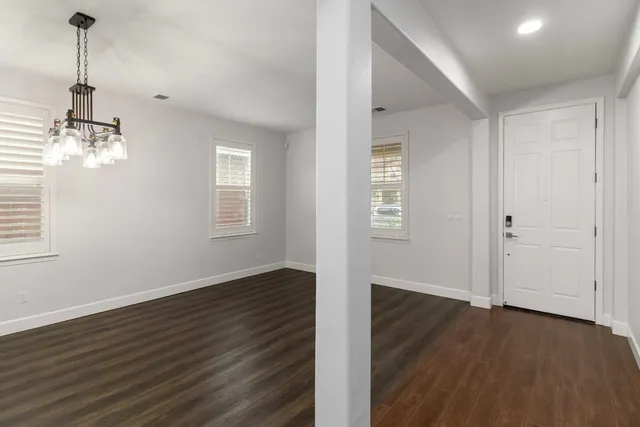a view of a room with wooden floor staircase and a kitchen