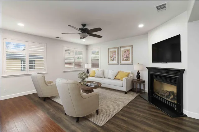 a view of an empty room with wooden floor fireplace and a window