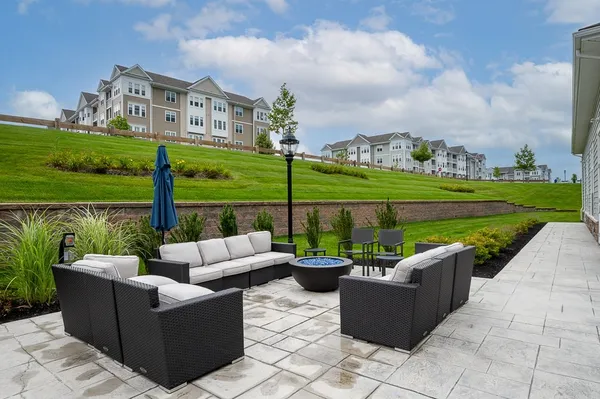 a view of a patio with couches potted plants and a big yard