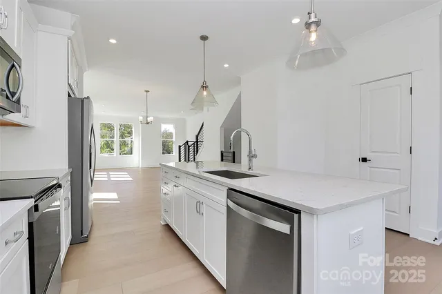 a kitchen with granite countertop a stove sink and microwave