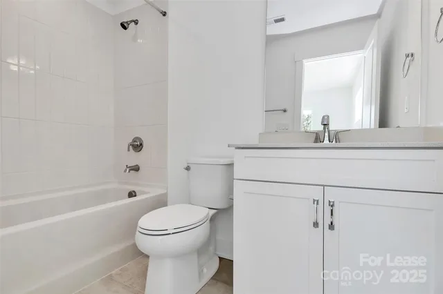 a bathroom with a granite countertop sink toilet a mirror and shower
