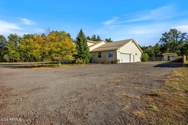 a view of a house with a big yard and palm trees