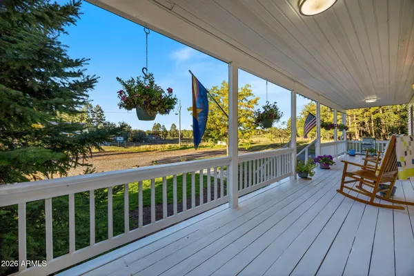 a view of a house with a small yard and large trees