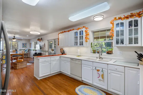 a kitchen with a sink cabinets wooden floor and stainless steel appliances