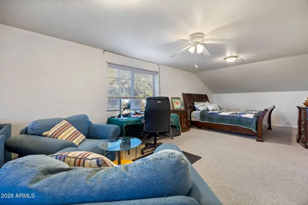 a bedroom with a bed a dresser and wooden floor