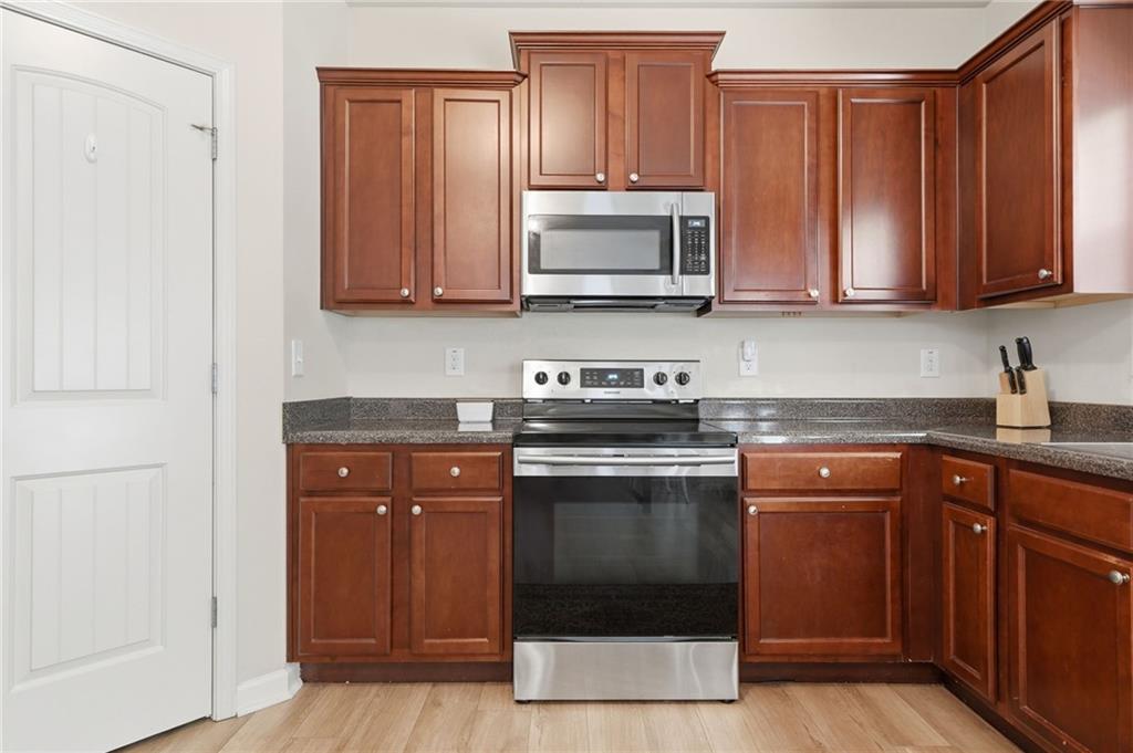 123 Renford Road Ball Ground, GA 30107 - Photo 11 of 27 a kitchen with stainless steel appliances granite countertop a stove a sink and a microwave