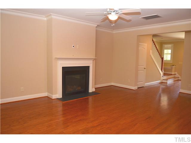 3517 Stonebend Loop Cary, NC 27518 - Photo 4 of 21 a view of an empty room with wooden floor and a fireplace