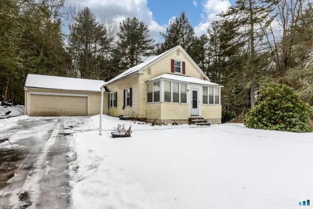 a front view of a house with a yard covered in snow