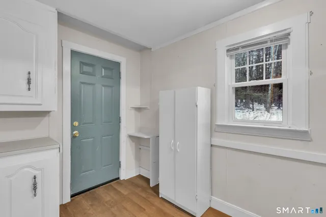 a view of a hallway with wooden floor and closet