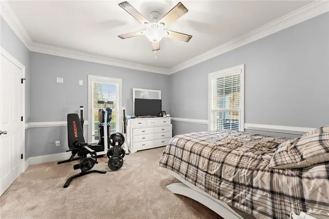 a bedroom with bed a window and gym equipment