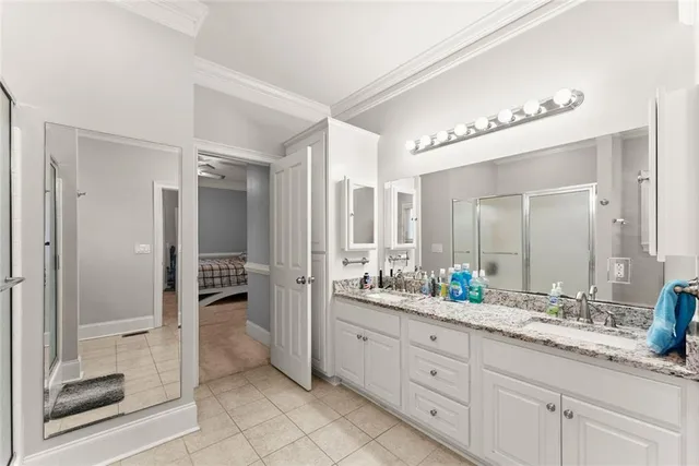 a spacious bathroom with a double vanity sink a mirror and a shower