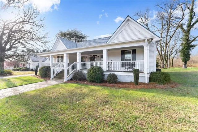 a view of a house with a big yard and potted plants