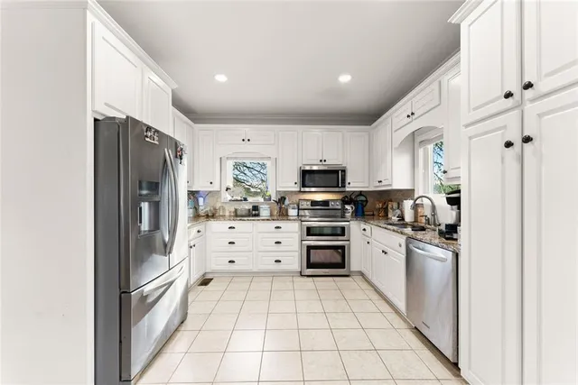a kitchen with stainless steel appliances a refrigerator sink and microwave
