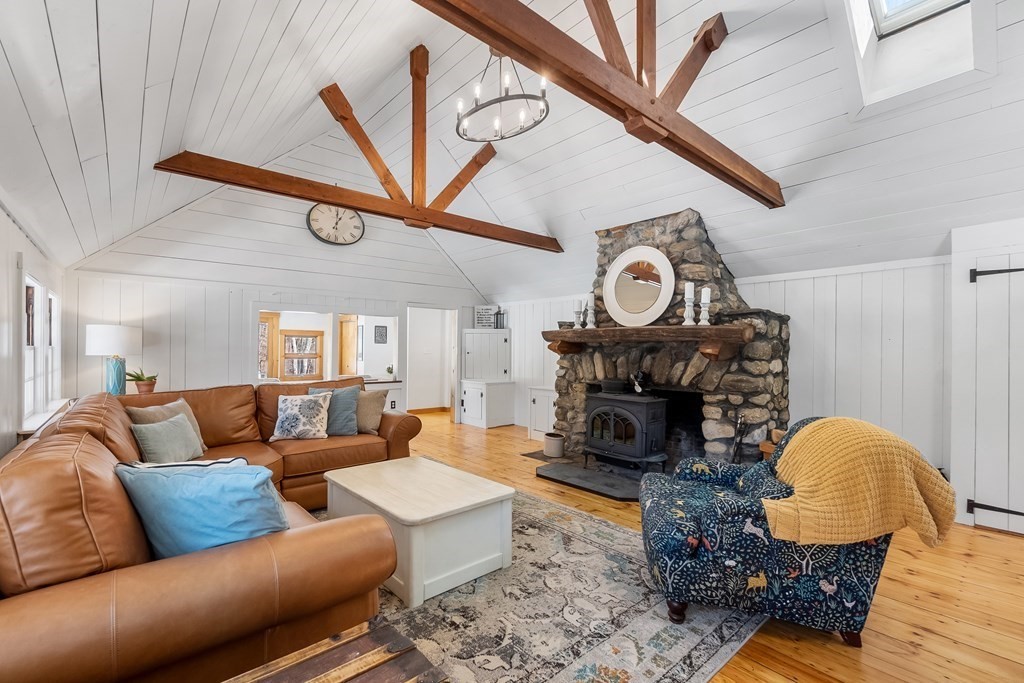472 Sugar Road Bolton, MA 01740 - Photo 12 of 30 a living room with furniture a fireplace and wooden floor