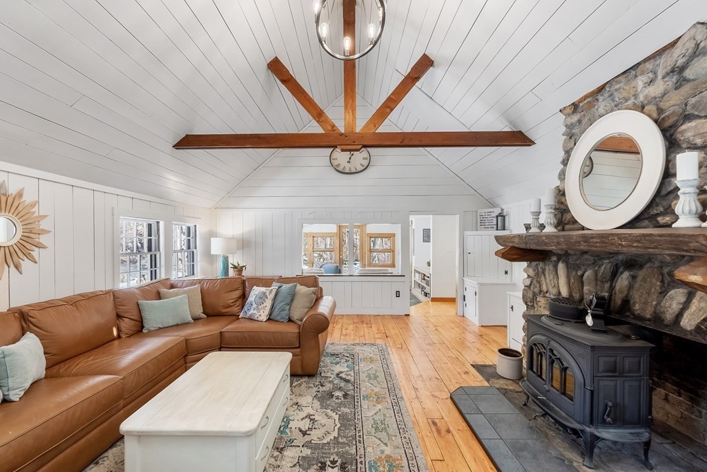 472 Sugar Road Bolton, MA 01740 - Photo 10 of 30 a living room with furniture a rug and a wall painting