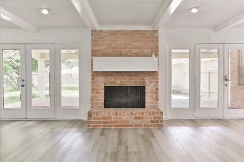 a living room with a fireplace and wooden floor
