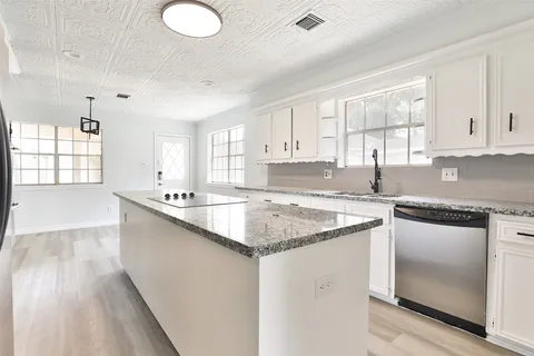 a kitchen with stainless steel appliances granite countertop a sink stove and cabinets