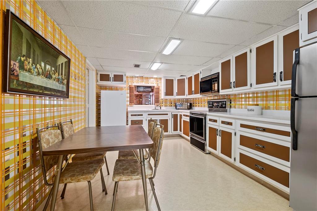 111 Morrow Road Beaver Falls, PA 15010 - Photo 38 of 50 a kitchen with stainless steel appliances granite countertop a stove top oven a sink a dining table and chairs with wooden floor