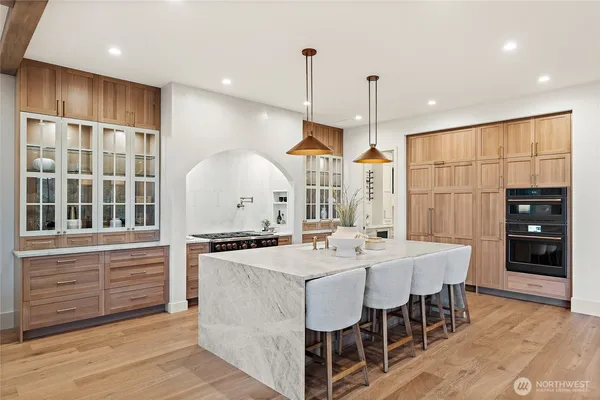 a kitchen with stainless steel appliances kitchen island granite countertop a stove a sink and a refrigerator