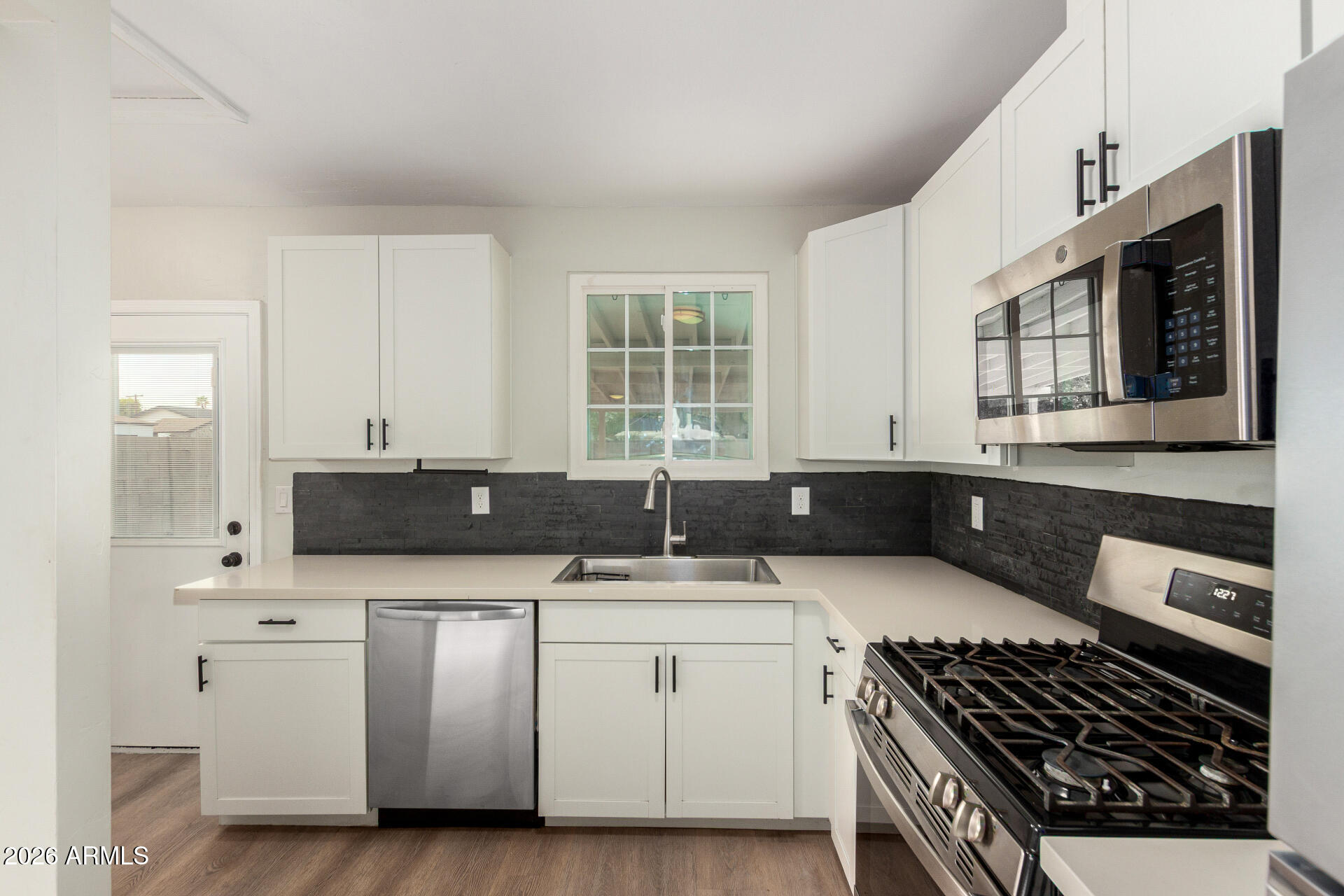 4010 North 11th Avenue Phoenix, AZ 85013 - Photo 12 of 22 a kitchen with stainless steel appliances a sink a stove and cabinets