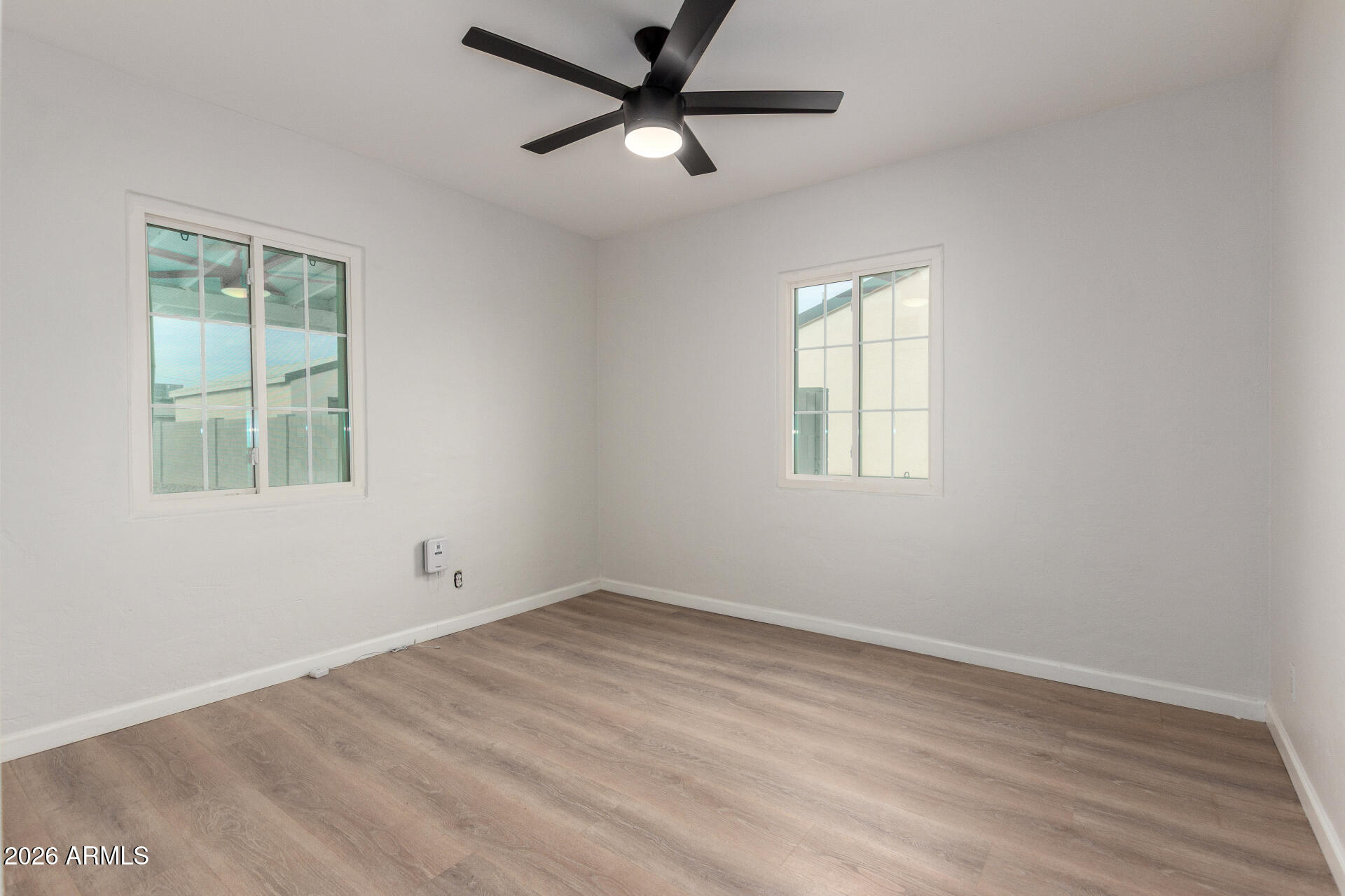 4010 North 11th Avenue Phoenix, AZ 85013 - Photo 13 of 22 an empty room with wooden floor and windows