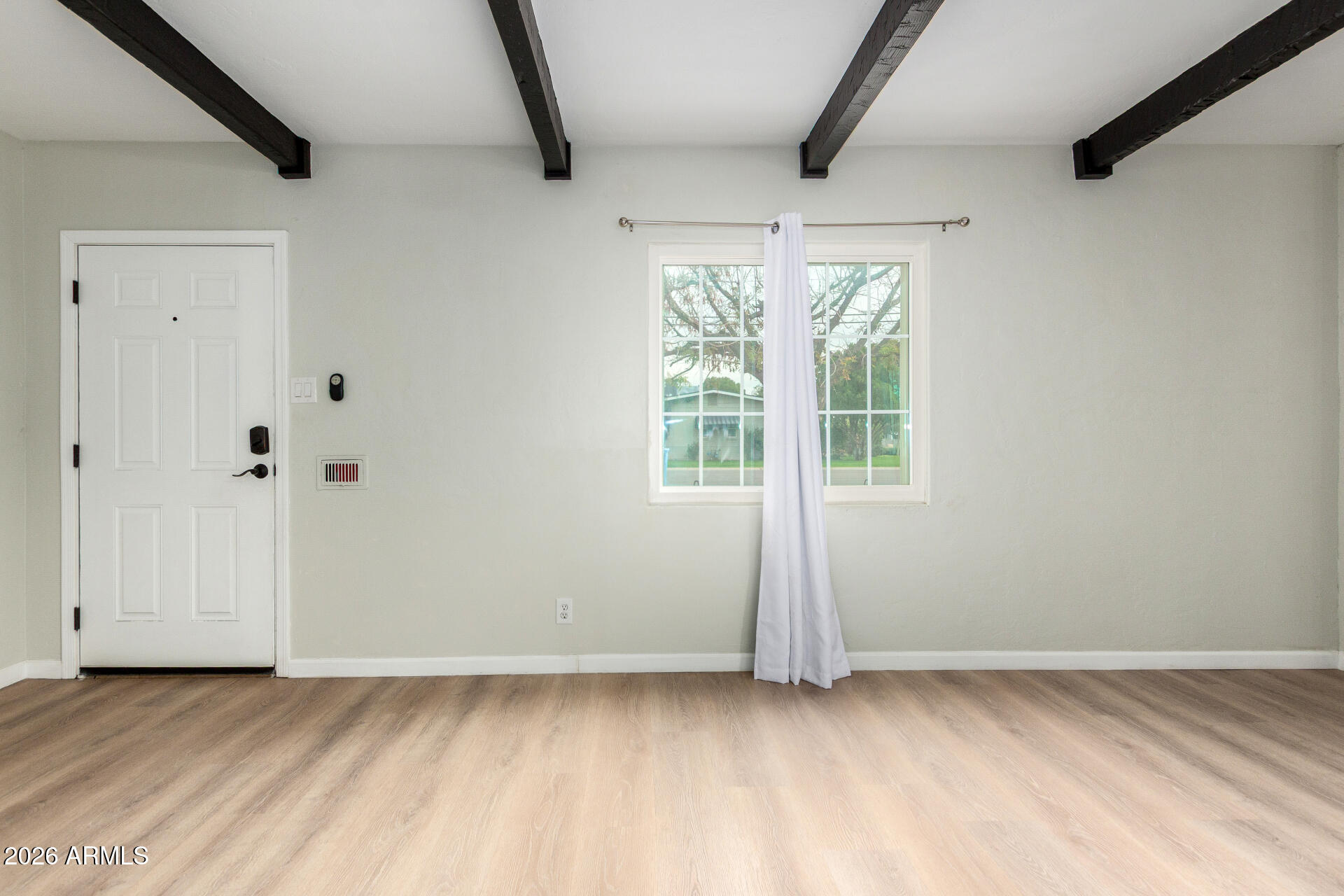 4010 North 11th Avenue Phoenix, AZ 85013 - Photo 4 of 22 an empty room with wooden floor and windows