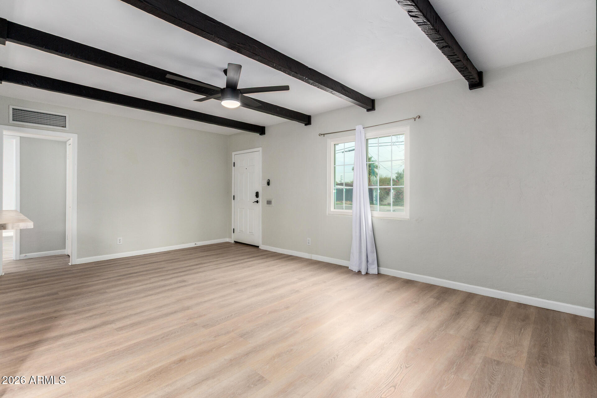 4010 North 11th Avenue Phoenix, AZ 85013 - Photo 6 of 22 an empty room with wooden floor ceiling fan and windows