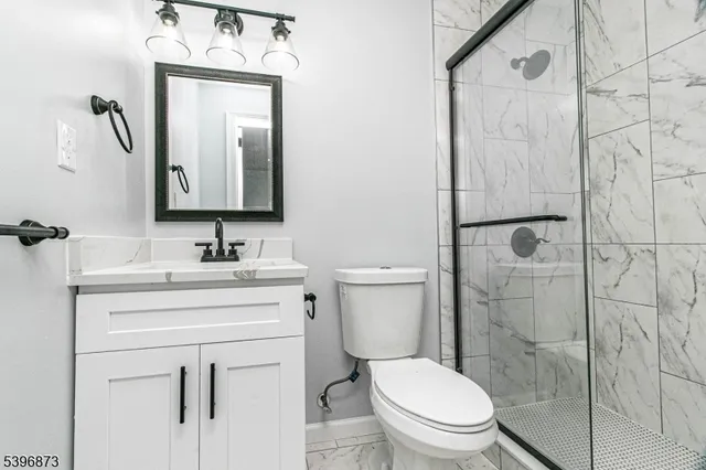 a bathroom with a toilet sink vanity and mirror