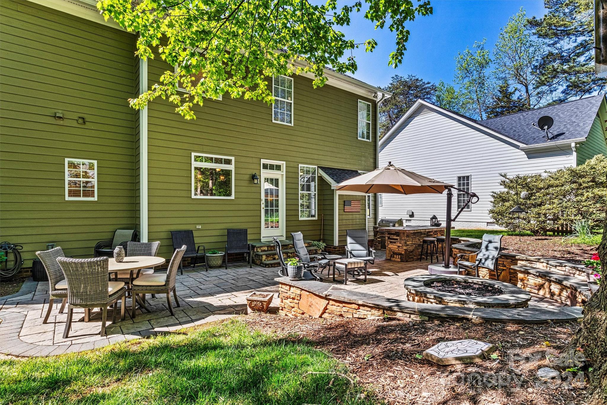 21329 Summerbrook Drive Cornelius, NC 28031 - Photo 45 of 46 a view of a patio with table and chairs under an umbrella
