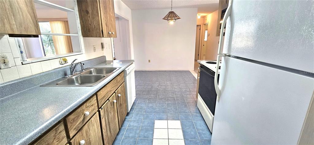 8449 Southwest 106th Place Ocala, FL 34481 - Photo 11 of 37 a kitchen with a sink and a refrigerator