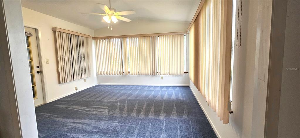 8449 Southwest 106th Place Ocala, FL 34481 - Photo 13 of 37 a view of an empty room with wooden floor and a window