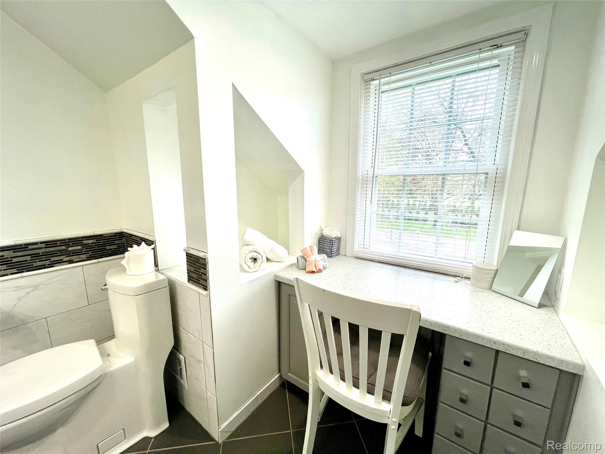 60 Devon Road Bloomfield Hills, MI 48302 - Photo 35 of 50 Integrated vanity desk with built-in storage drawers, a large window, and tile flooring