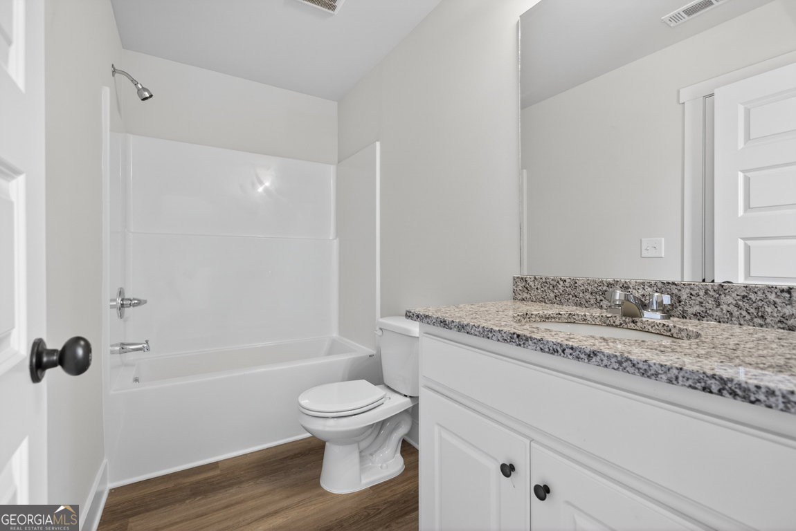 198 Mockingbird Lane, Unit 30 Winder, GA 30680 - Photo 19 of 39 a bathroom with a granite countertop toilet and a sink