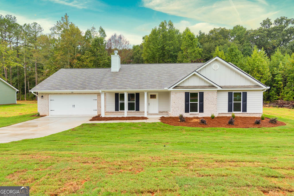 198 Mockingbird Lane, Unit 30 Winder, GA 30680 - Photo 2 of 39 a front view of a house with a garden and trees